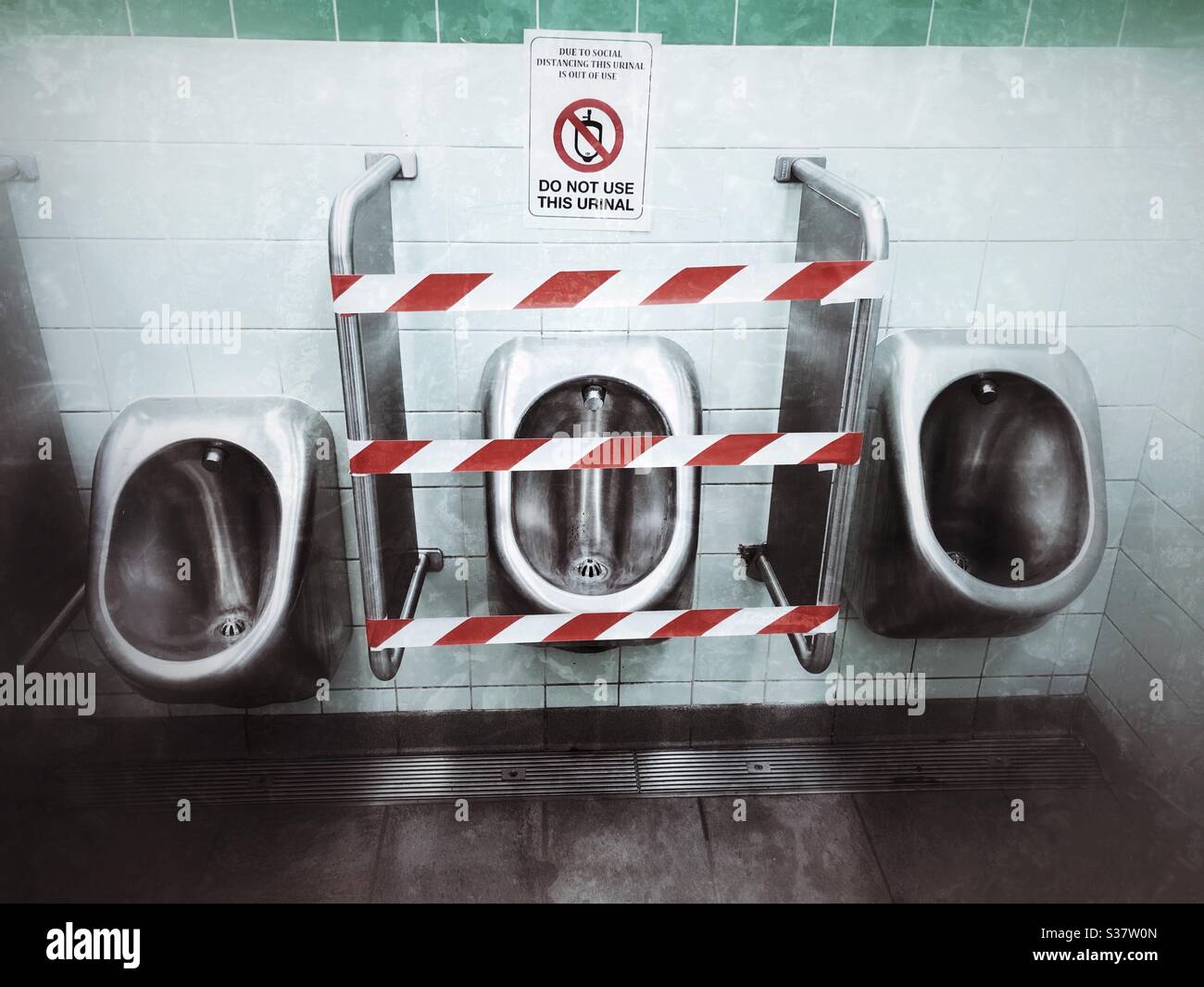 Gents Pub Toiletten mit mittleren Urinal abgetaped von sozialen Distanzierungsregeln Juli 2020 Großbritannien Stockfoto
