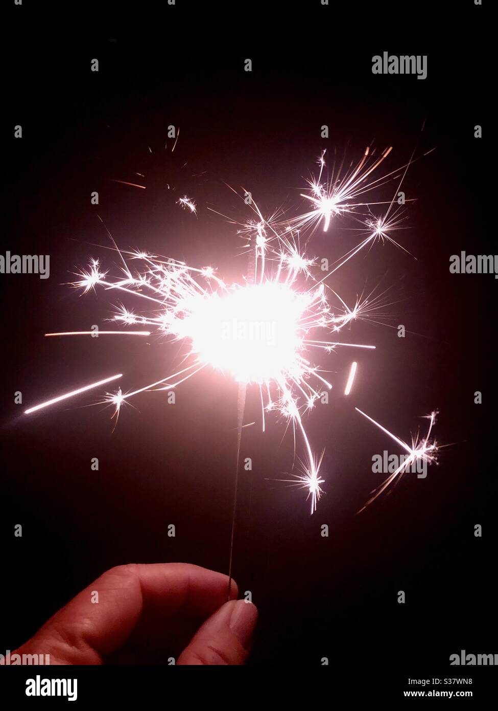Hand hält eine Wunderkerze Stockfoto