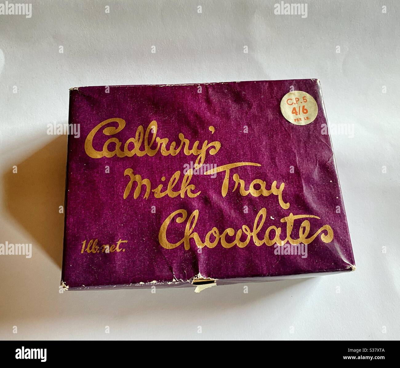 Eine alte, zerschlagene Schachtel mit Cadbury's Milchtablett Pralinen in einer 1lb Box und wurde ursprünglich für 4 Schillinge und 6 Pence verkauft. - Smartphone-aufgenommenes Stockfoto