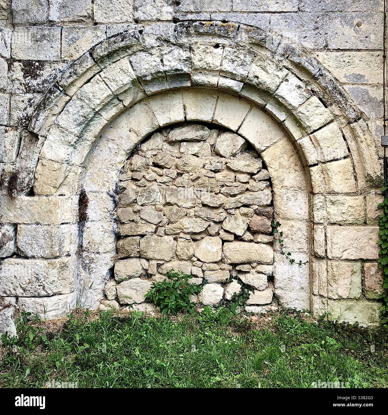 Blockierter Eingang zur Unterkirche der alten Kirche in Ferrière-Larçon, Indre-et-Loire, Frankreich. - Smartphone-aufgenommenes Stockfoto