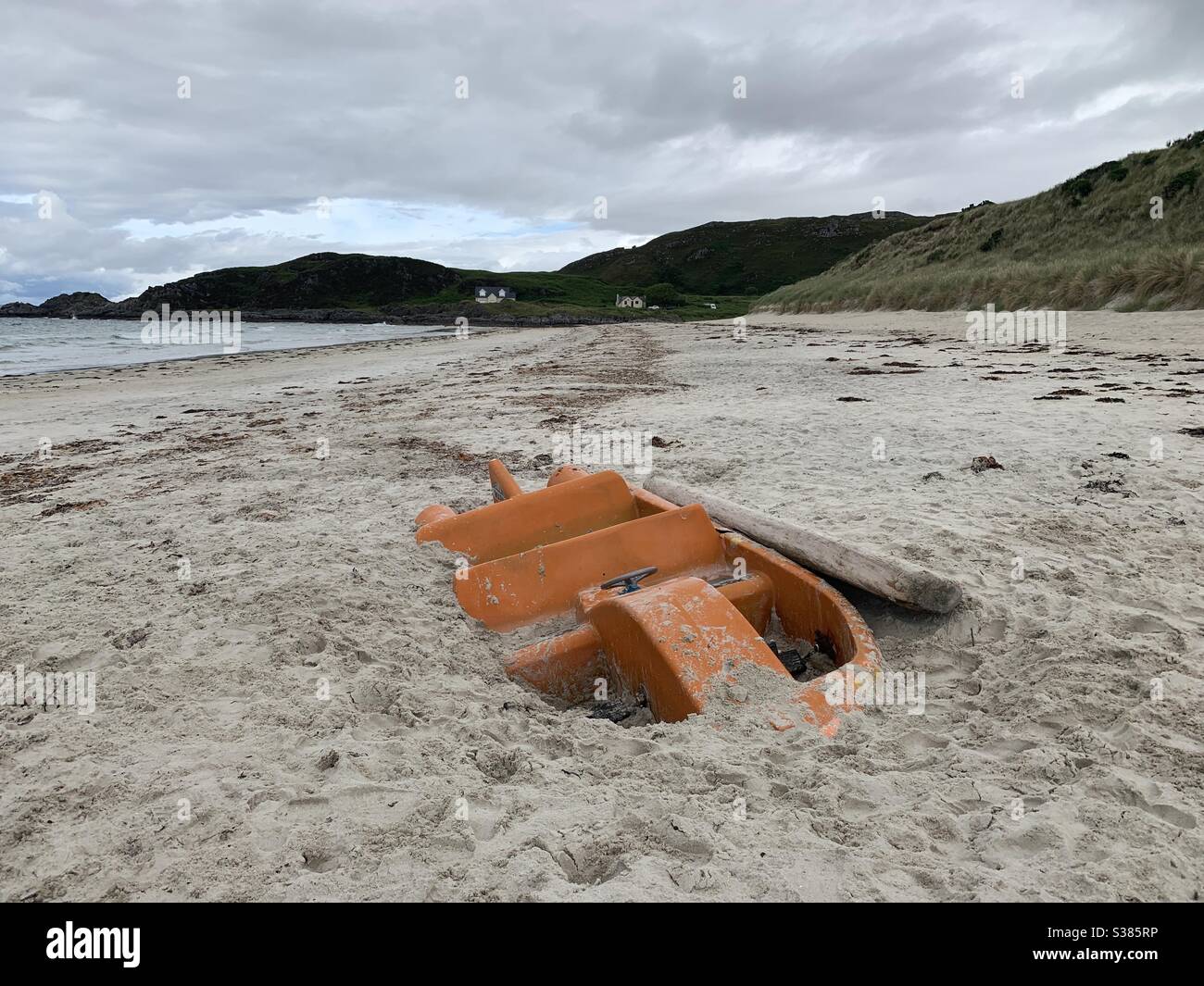 Ein Tretboot, das an einem Strand in den schottischen Highlands begraben ist Stockfoto