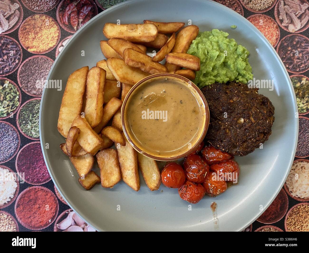 Montreal Spice Burger, Steak Fries, Peppercorn Sauce und Mushy Peas - Smartphone-aufgenommenes Stockfoto
