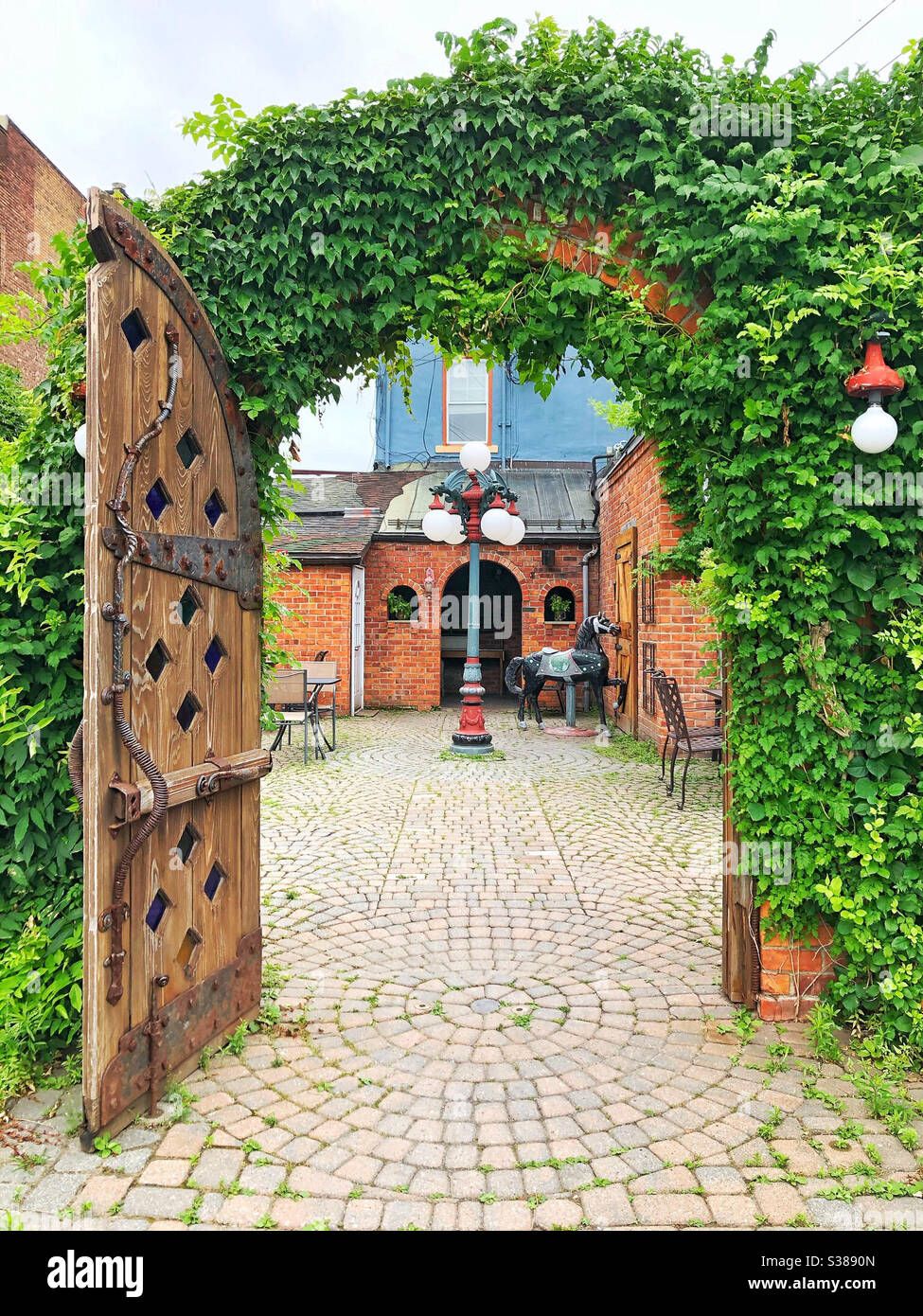 Essen im Freien im charmanten Efeu überdachten Innenhof - Smartphone-aufgenommenes Stockfoto