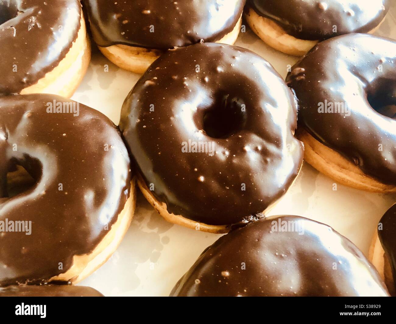 Draufsicht auf einen Rahmen von Schokolade überzogenen Donuts in einer weißen Box Stockfoto