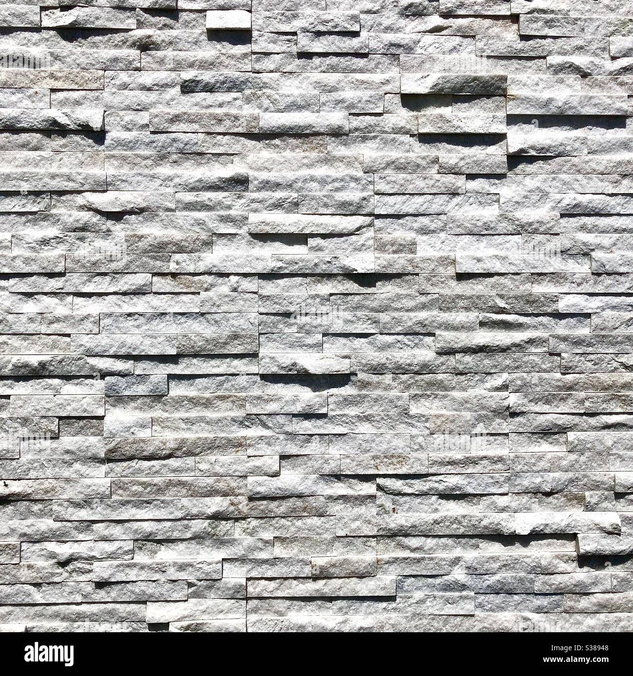 Strukturierte weiße Wandverkleidung aus falschem Marmor. - Smartphone-aufgenommenes Stockfoto