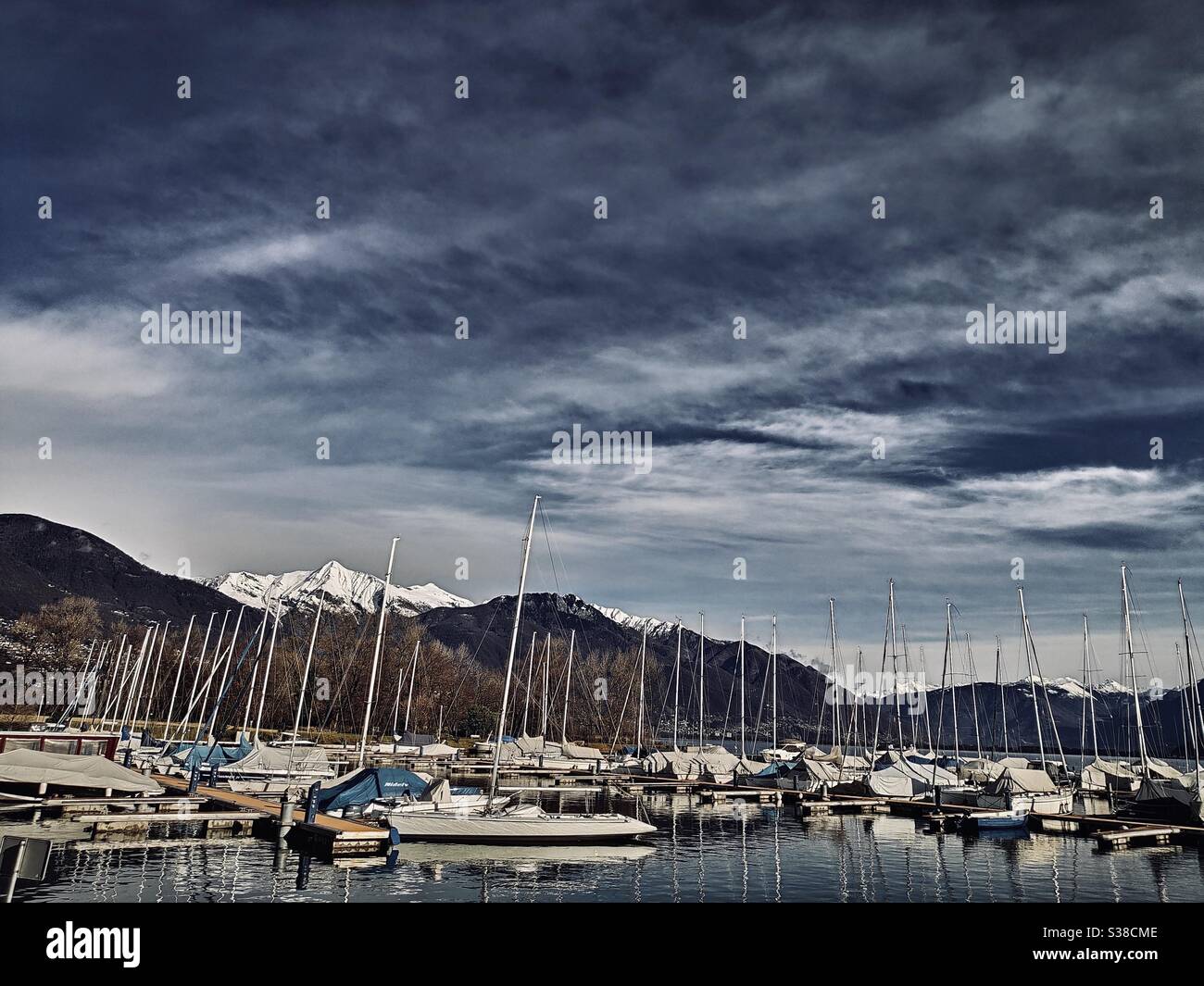 Boote, die am kleinen Hafen in der Nähe des Lago Maggiore in Ascona, Schweiz, geparkt sind - Smartphone-aufgenommenes Stockfoto