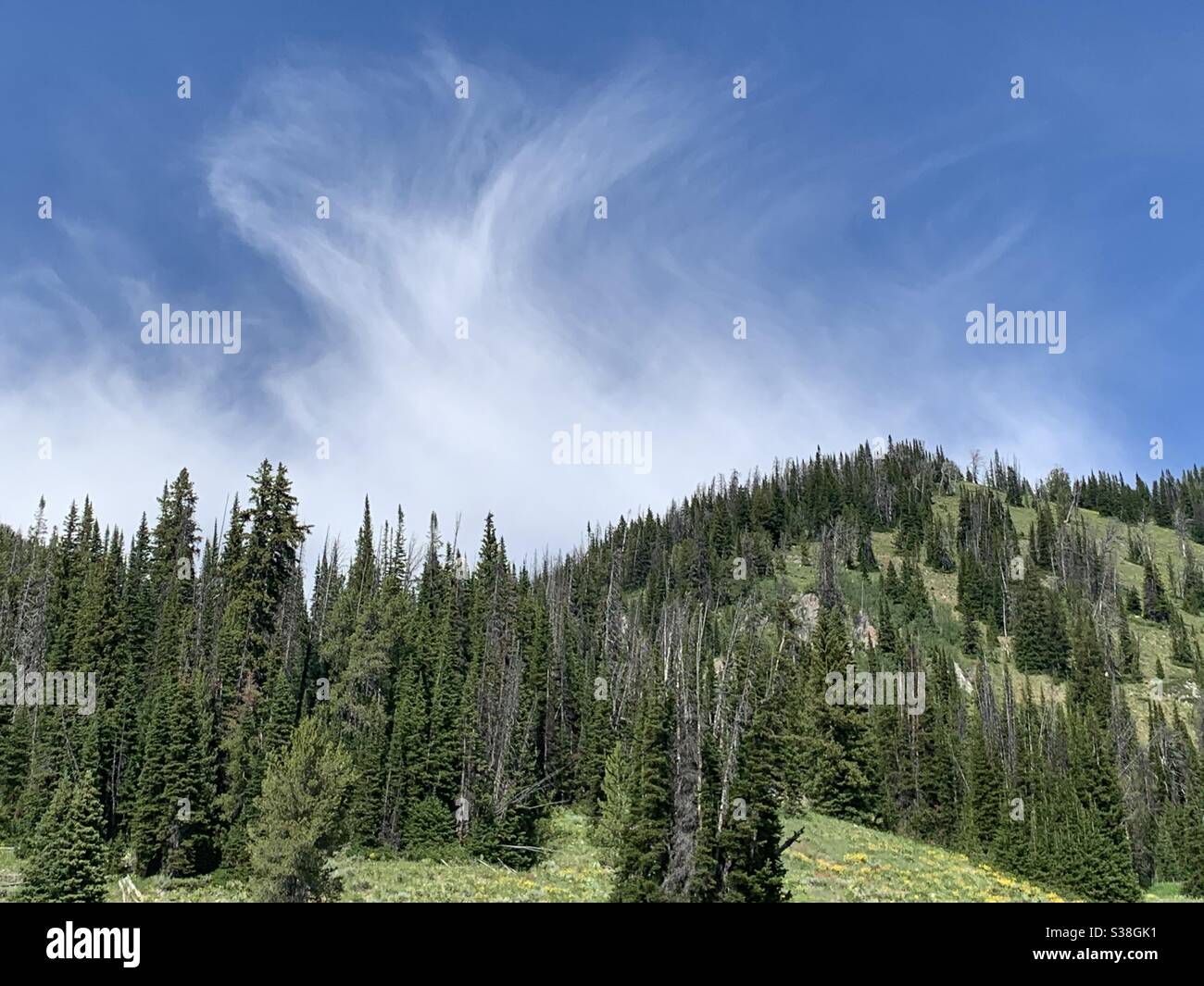 Eine wispy Wolke tanzt über dem Berg Stockfoto