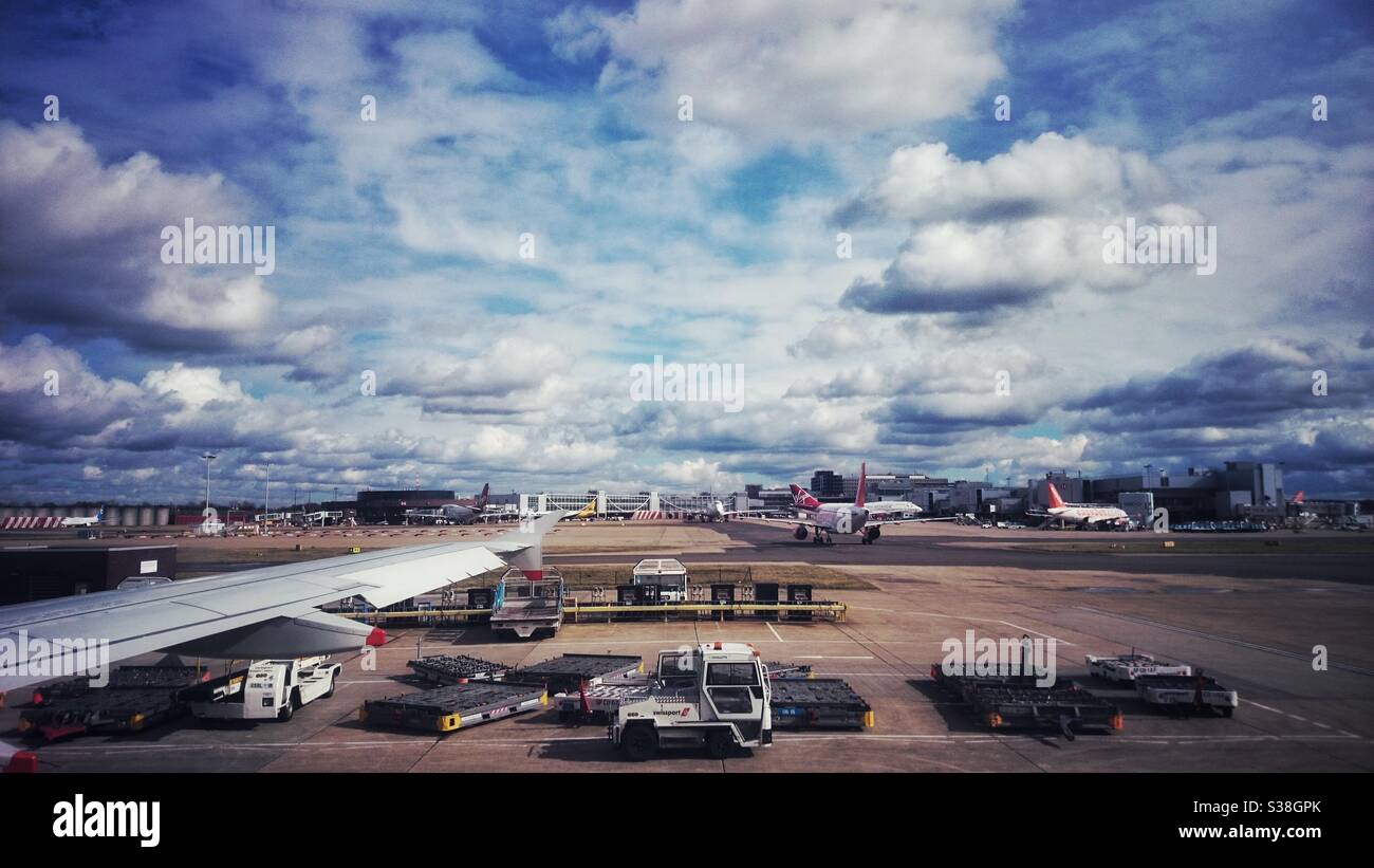 Ein Foto von einem belebten Flughafen mit Flugzeugen und Fahrzeugen, aufgenommen aus dem Inneren eines Flugzeugs. Reisen, Urlaub, Tourismus Foto. Stockfoto
