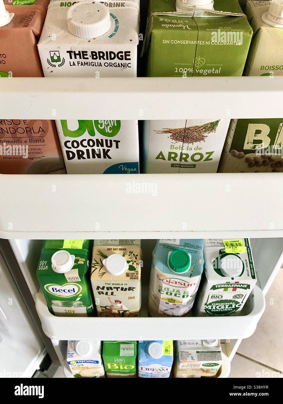 Kartons mit gesunden, werksbasierten alternativen Mühlen in Kühlschranktüren, die im Falle einer Pandemie-Sperre gelagert werden. Stockfoto