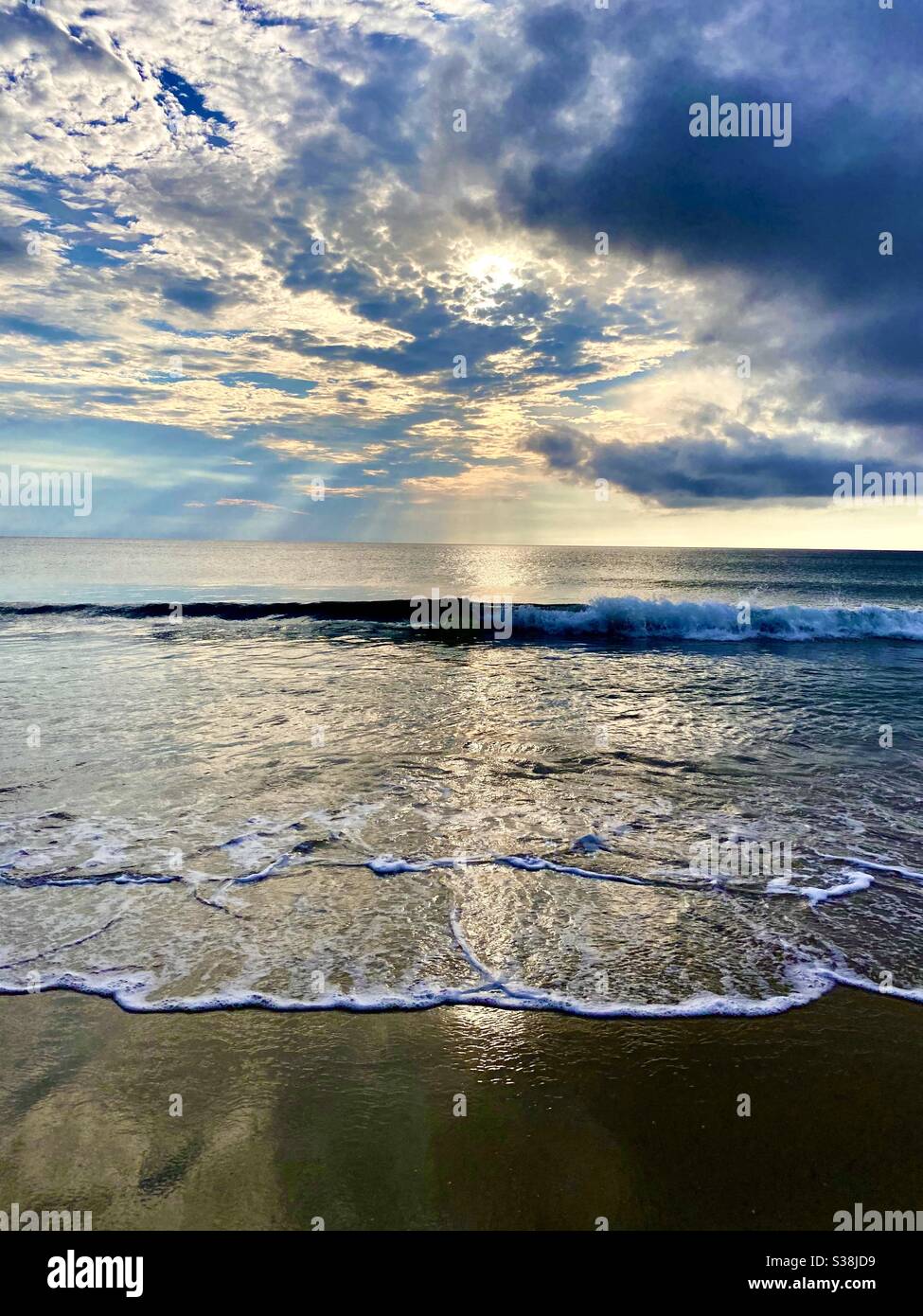 Schöner Sonnenaufgang am Strand an einem bewölkten Morgen Stockfoto