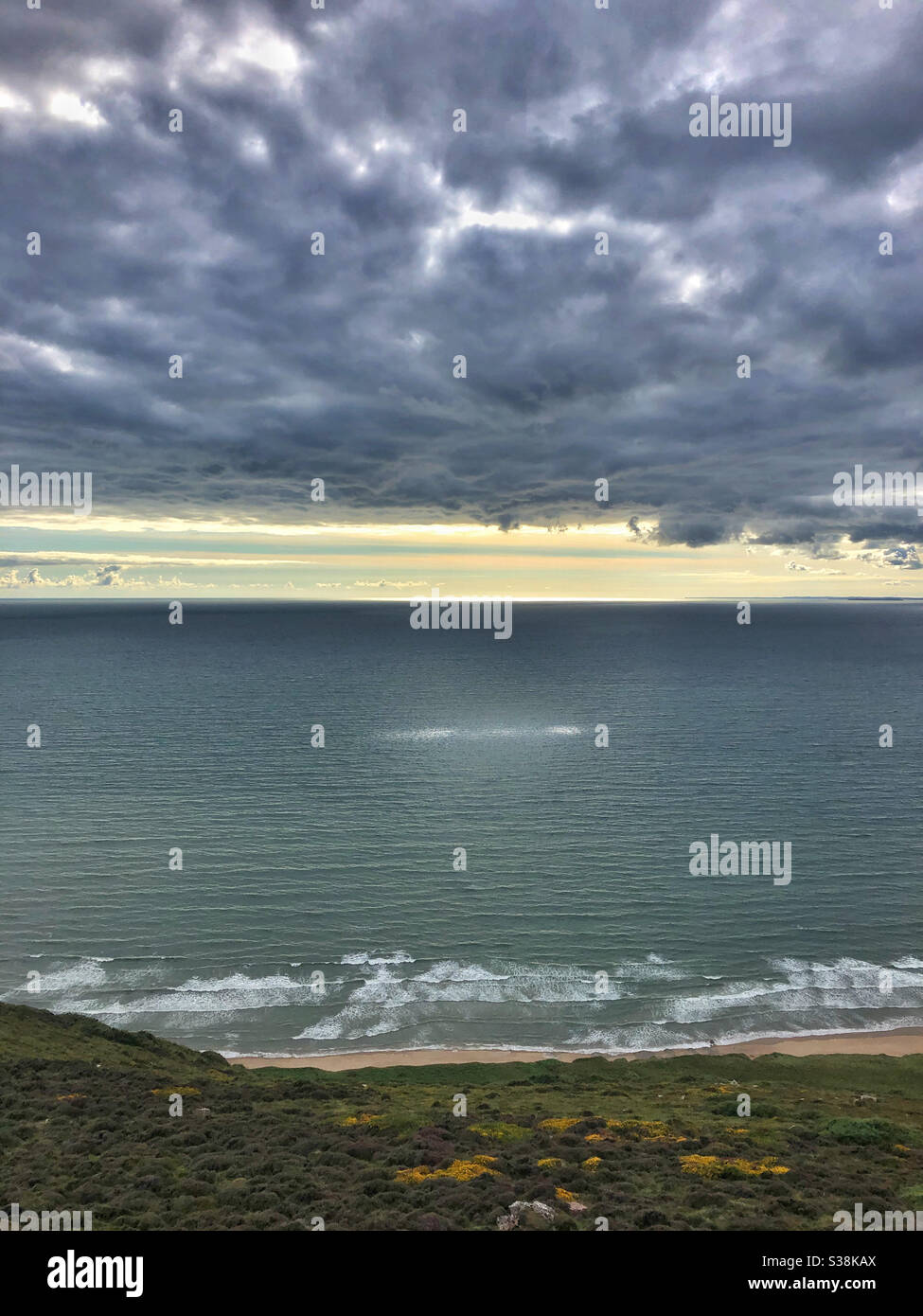 Schwere Wolke über dem Meer mit einem einzigen Ausbruch von Licht kommt durch Stockfoto