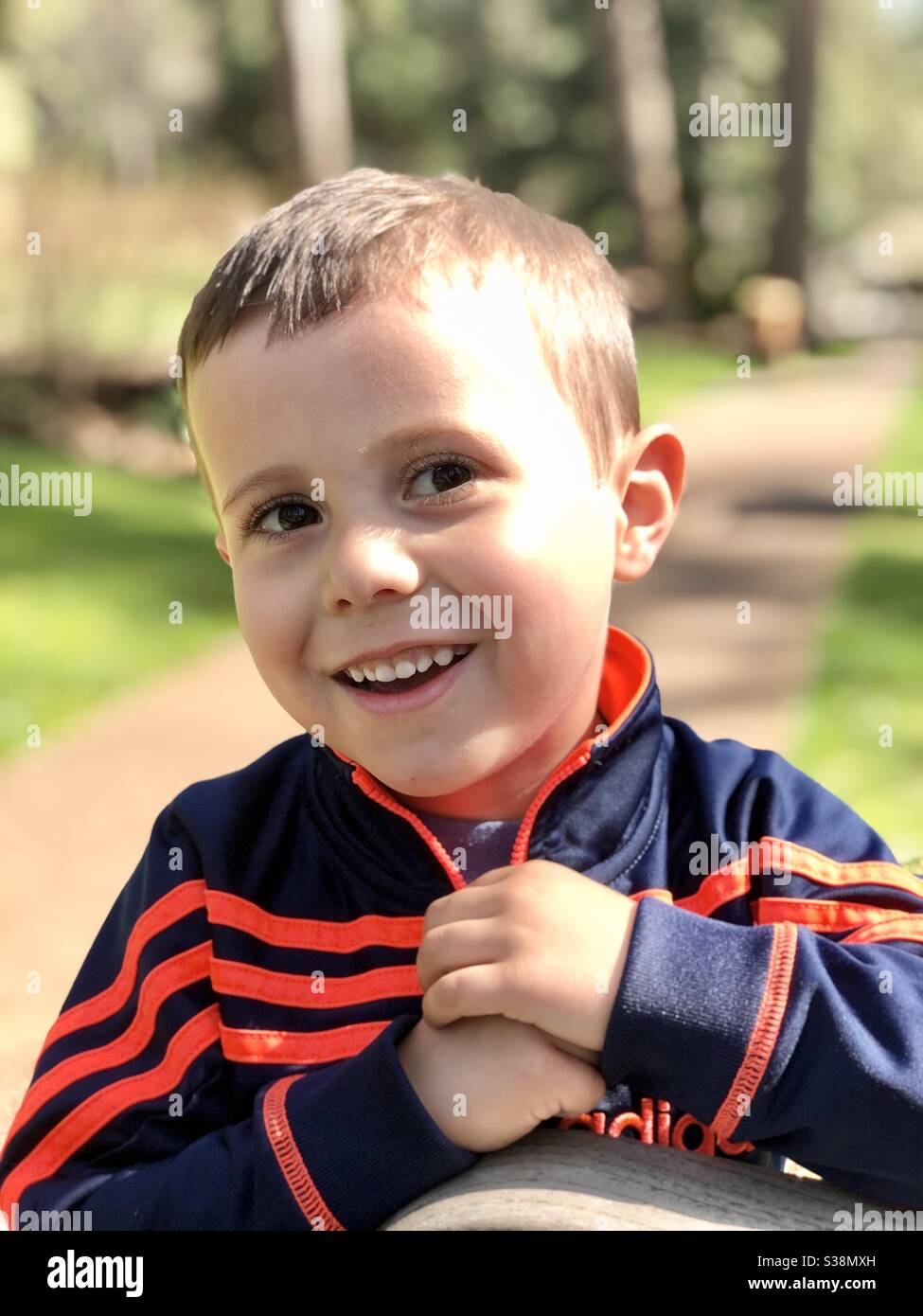 Kleinkind Junge mit einem schüchternen Lächeln Blick aus auf die Seite Stockfoto