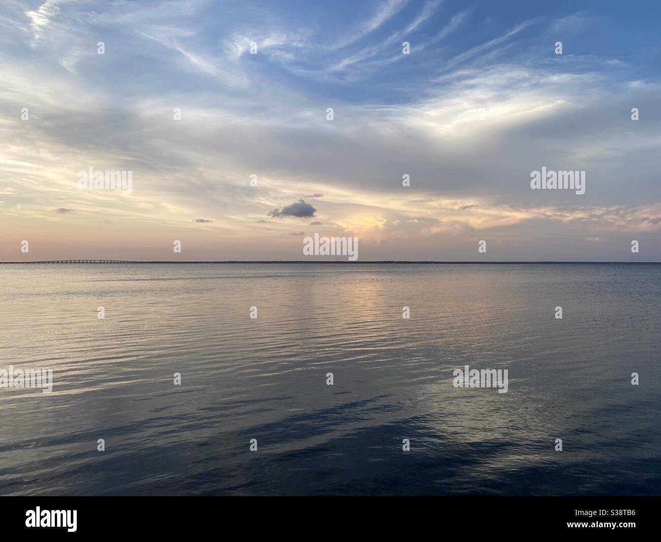 Sonne, die in weichen weißen, flauschigen Wolken über dem Lorbewasser reflektiert wird Bei Sonnenuntergang Stockfoto