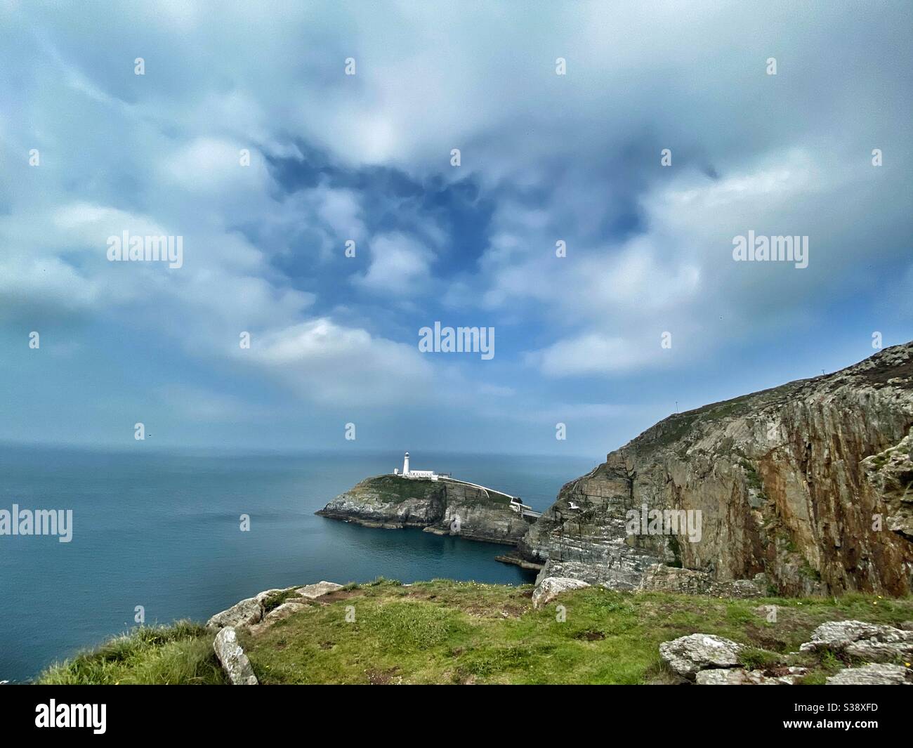Südstapel Leuchtturm, Anglesey, Nordwales, Weise Winkel Ansicht, Landschaft Zusammensetzung, mit einigen der Festland in der Aufnahme, dunstig Tag im August 2020. Stockfoto