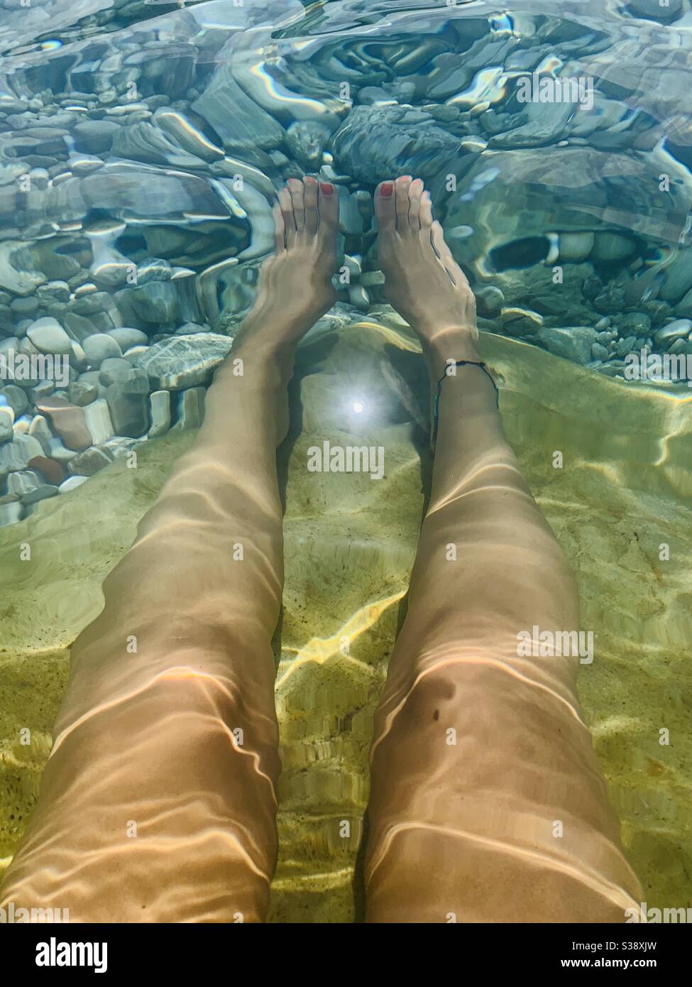 Beine unter Wasser mit leichten Wellen Stockfoto