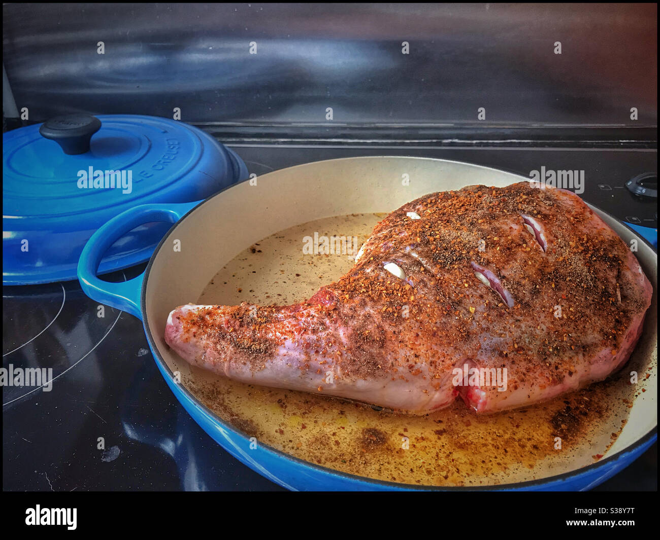 Lammkeule gefüllt mit Knoblauch, bereit, in den Ofen zu gehen. Stockfoto