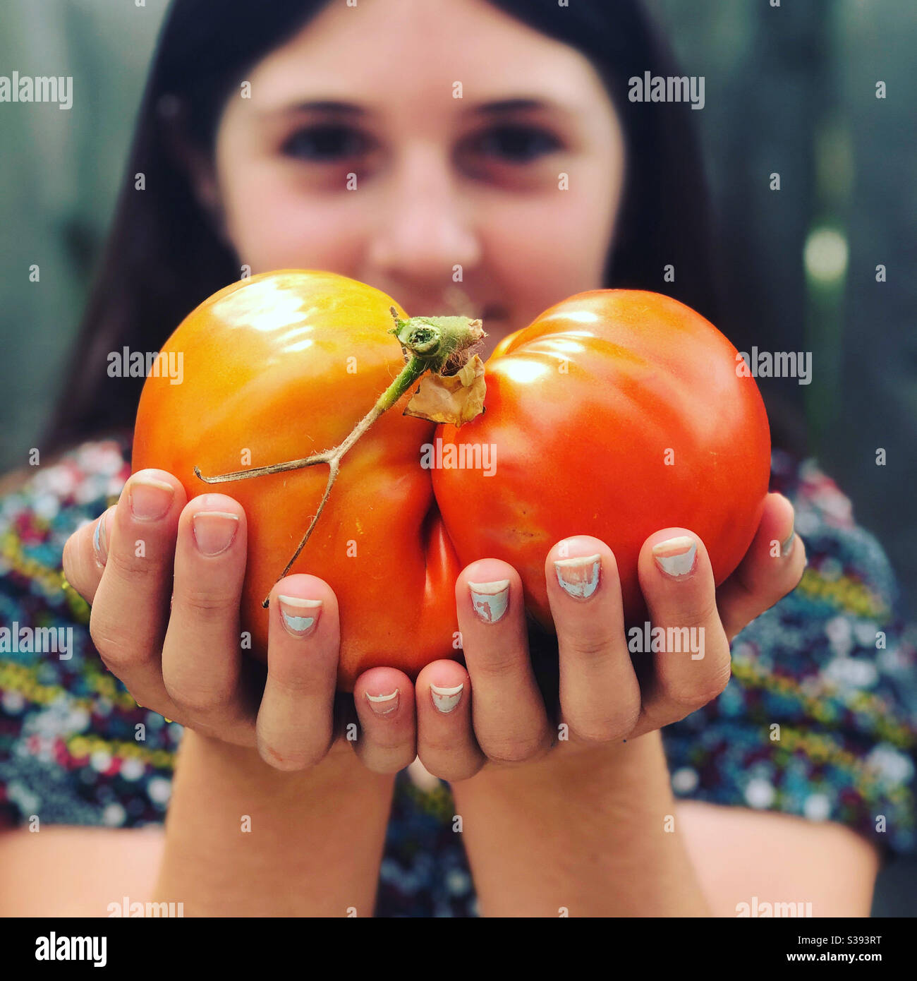 Junges Mädchen mit großen Tomaten Stockfoto