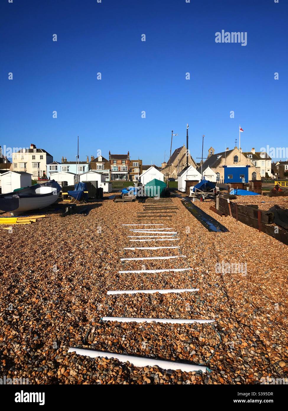 Fischerboote vertäuten am Strand hinter Strandhütten Walmer Deal Kent Großbritannien - Smartphone-aufgenommenes Stockfoto