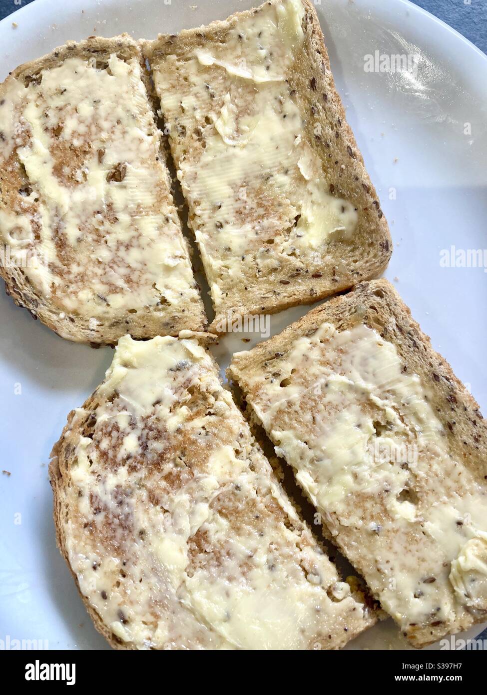 Brauner, gebutterter, mehrkörniger Toast mit Saatkorn Stockfoto