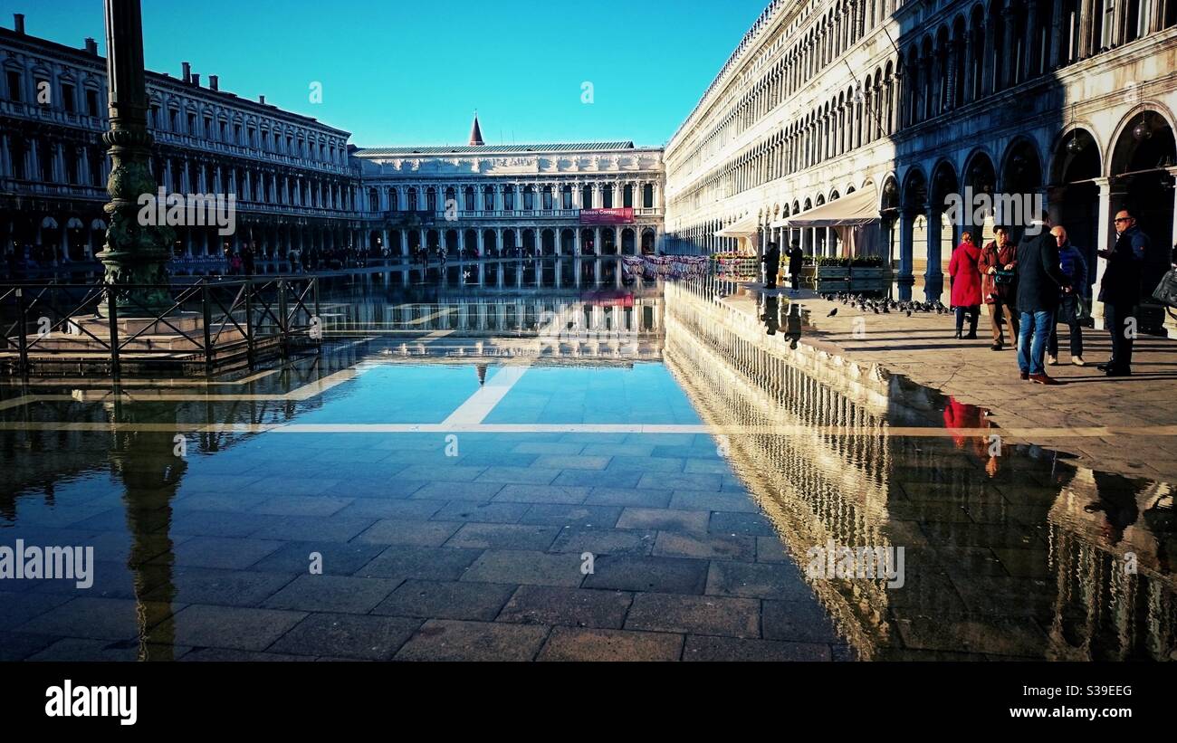 Ein Foto von Hochwasser (Acqua alta) in Venedig, Italien. Wenige Touristen, schöner sonniger Tag auf dem Markusplatz. Piazza di San Marco, Venedig. Stockfoto