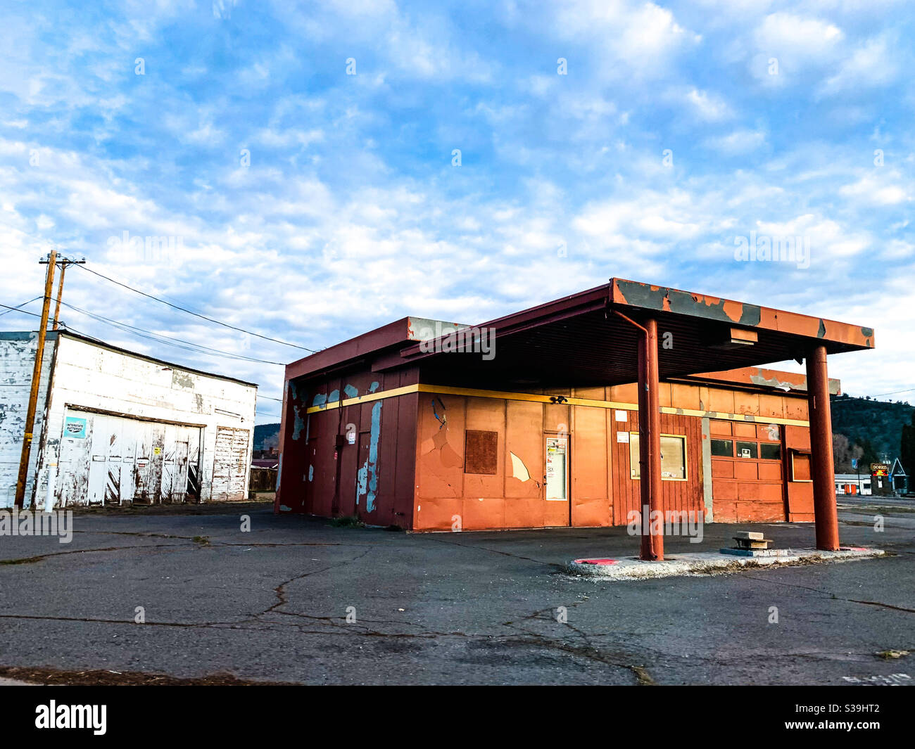 Verlassene Tankstelle und Garage in Nordkalifornien im frühen Morgenlicht unter blauem Himmel und weißen Wolken. Stockfoto