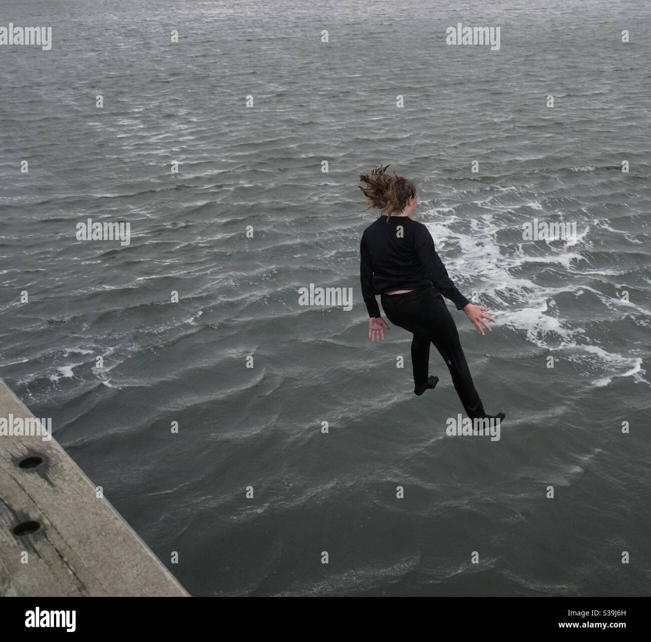 Mädchen, die ins Meer springen Stockfoto