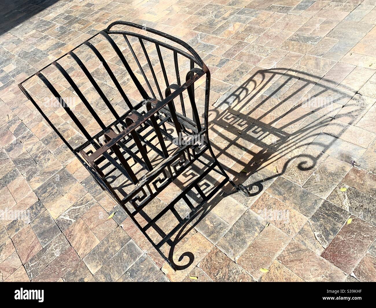 Eisenstuhl reflektiert in einem herzförmigen Schatten auf dem Boden Stockfoto