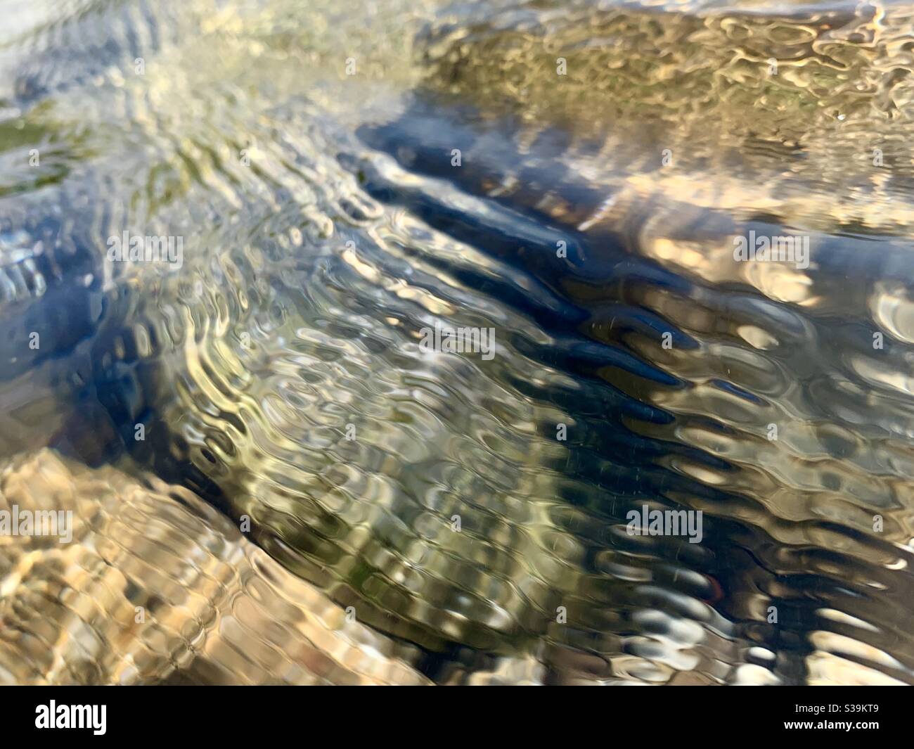 Wellen von Wasser, die über Steine in einem Fluss fließen Stockfoto