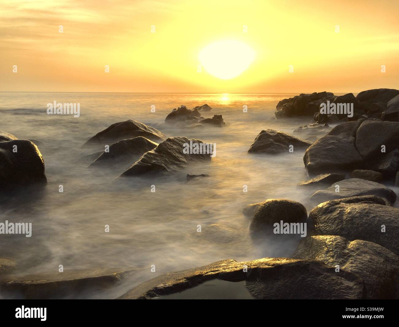 Nebliger Sonnenuntergang am Meer Stockfoto