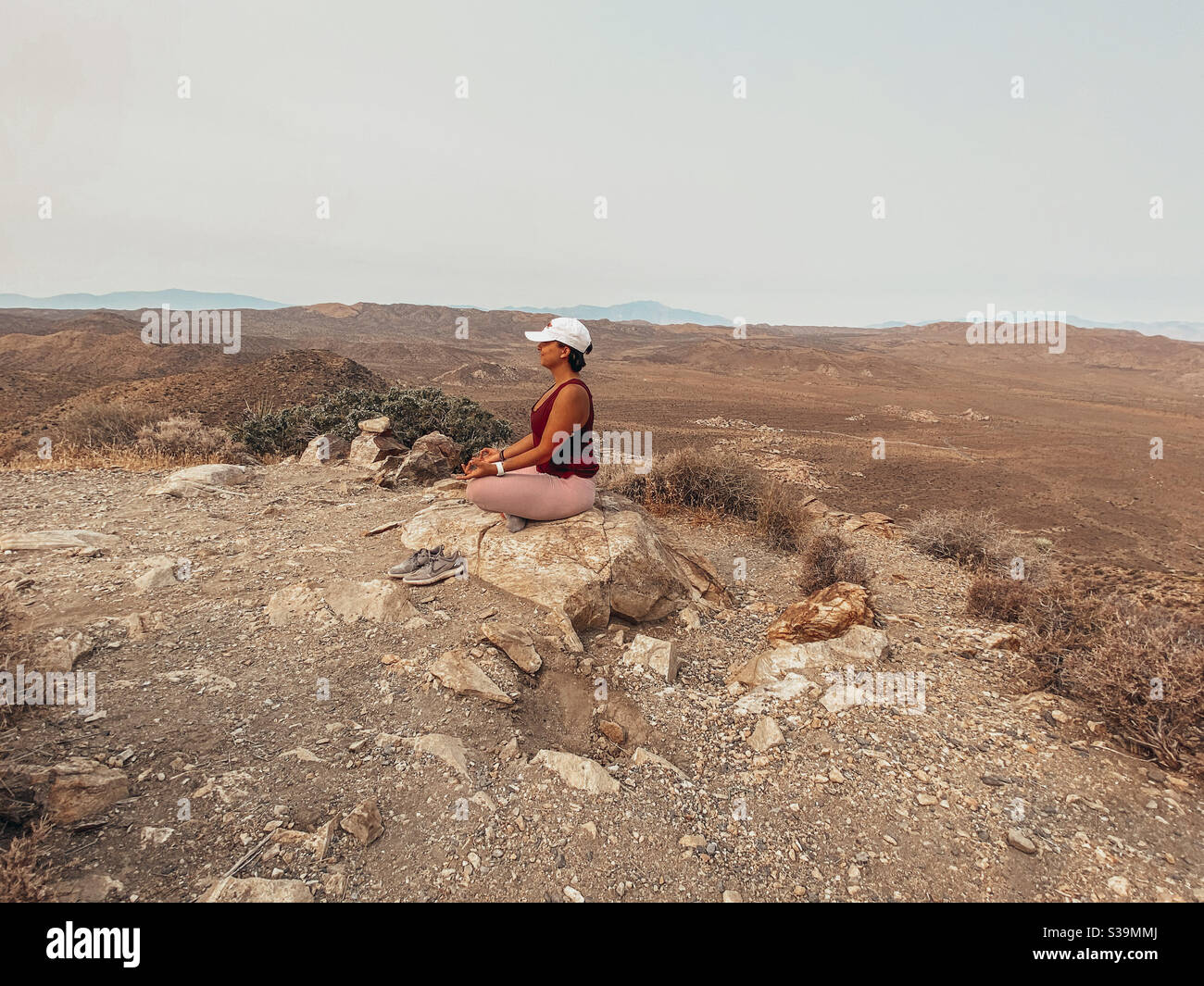 Meditieren in der Wüste auf einem Felsen Stockfoto