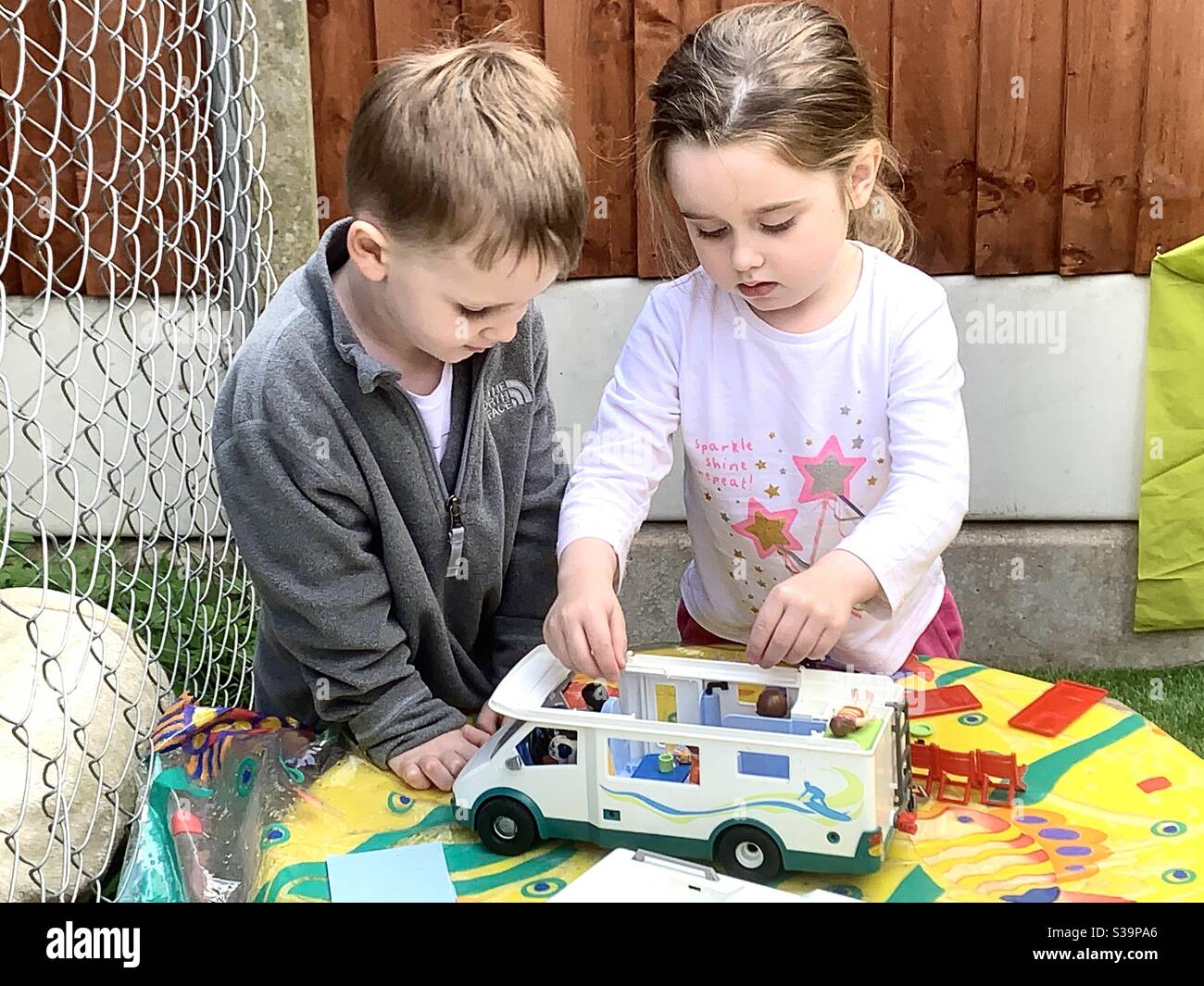 Kinder verzogen mit einem Spielzeug Wohnmobil spielen Stockfoto