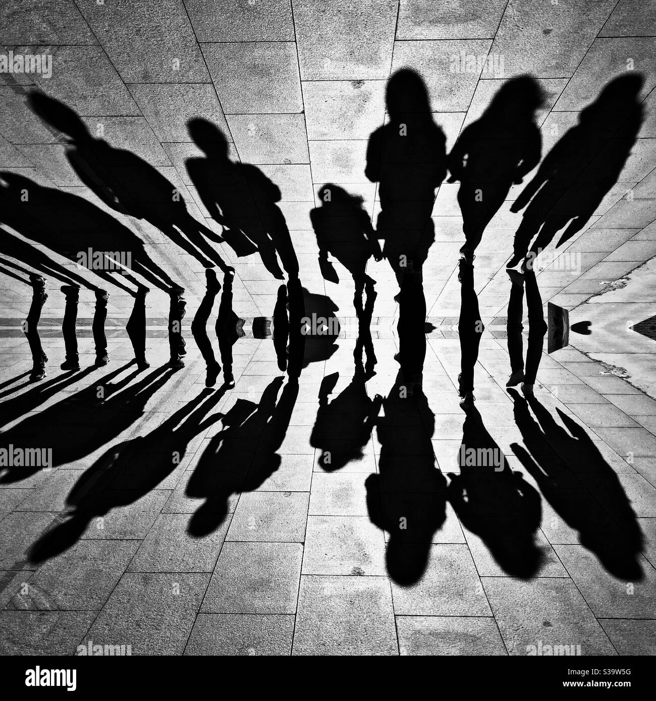 Spiegelwirkung der Gruppe von Menschen Schatten auf der Straße zu gehen. Stockfoto