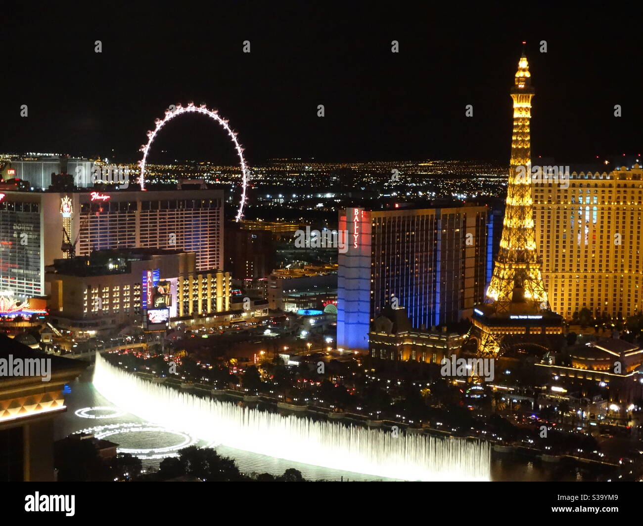Bellagio Brunnen bei Nacht in Las Vegas, hoher Aussichtspunkt mit Eiffelturm und das Rad im Blick Stockfoto