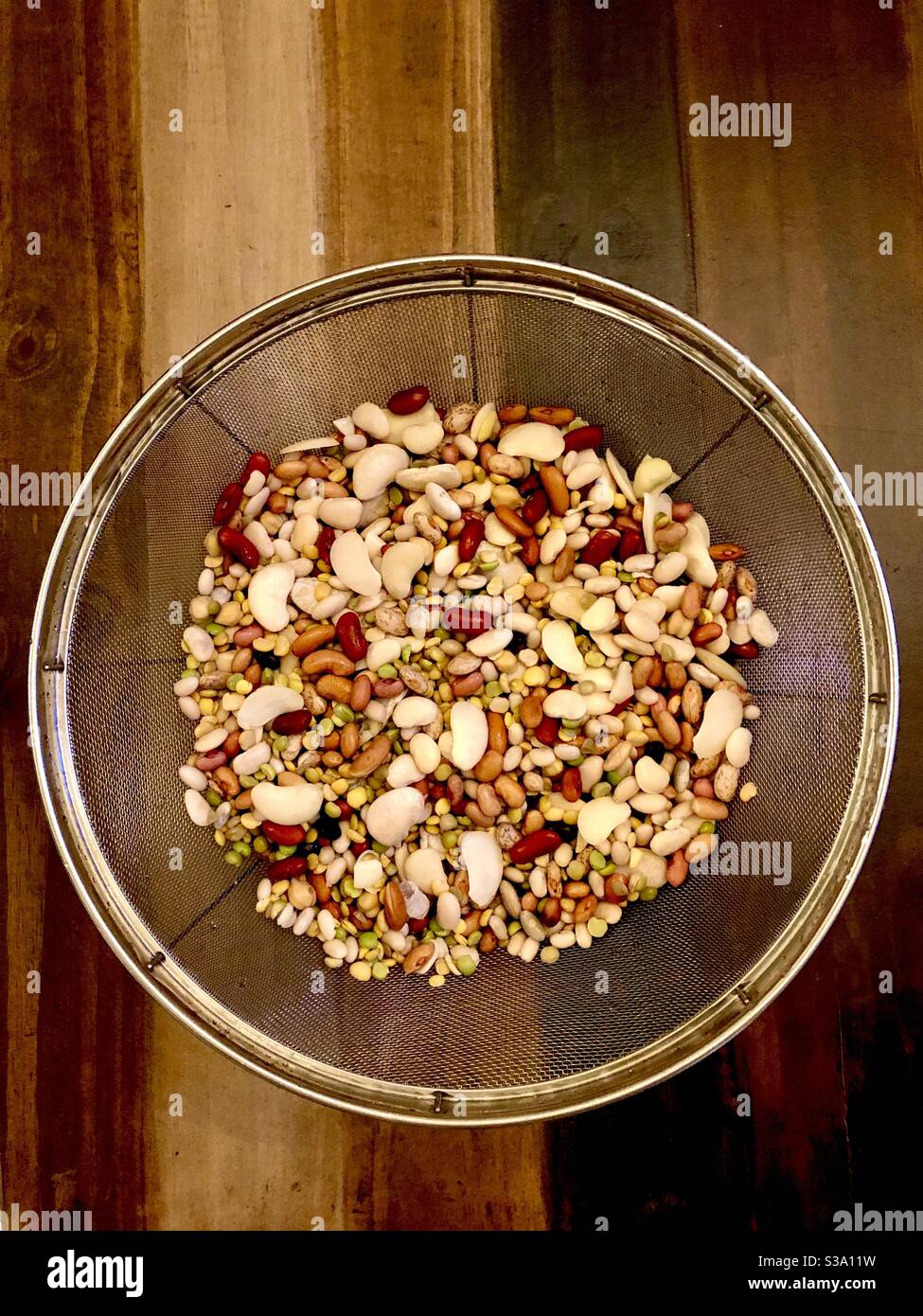 Eine Vielzahl von 15 Arten von getrockneten Bohnen in einem Sieb. Stockfoto
