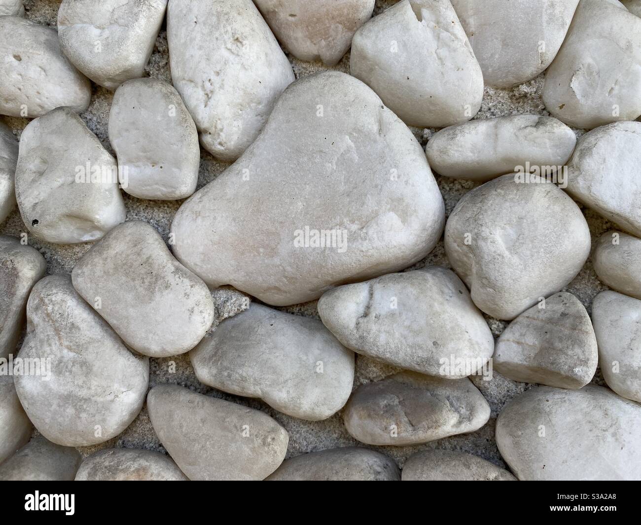 Abstrakte Hintergrundtextur aus großen, glatten, grauen Steinen - Smartphone-aufgenommenes Stockfoto