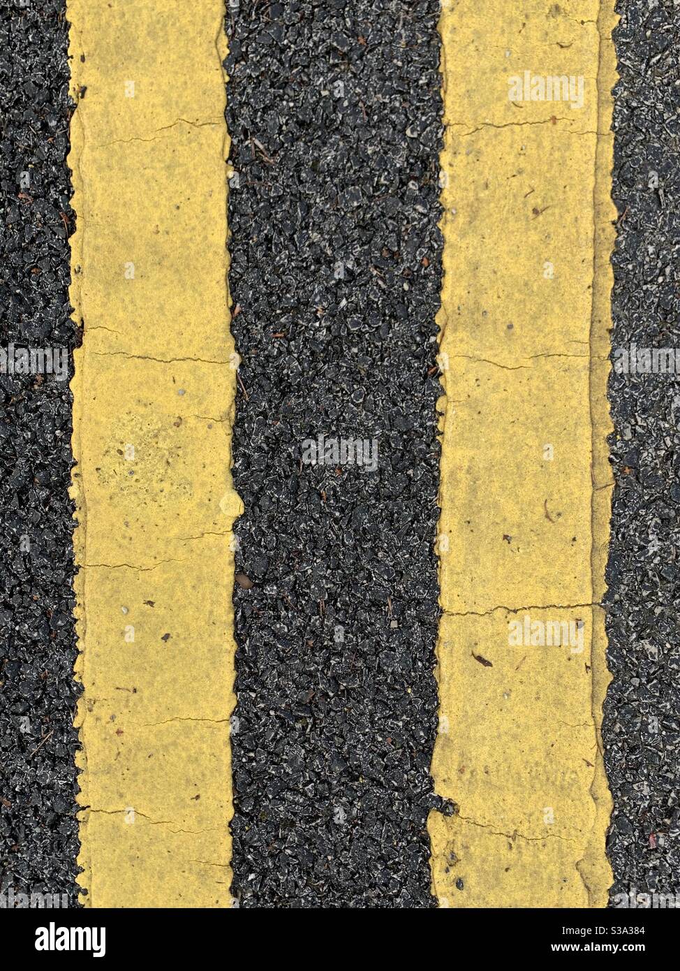 Doppelte gelbe Linien auf Asphalt. Parkeinschränkung. Parken war okay. Kein Parkplatz Stockfoto