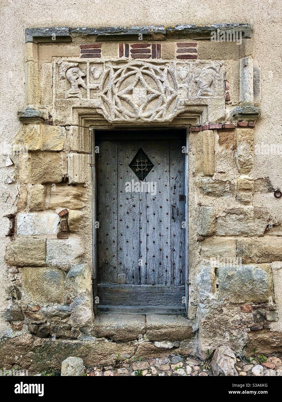 Geschnitzter mittelalterlicher Steinkopf zum Eingang in Saint-Benoit-du-Sault, Indre, Frankreich. - Smartphone-aufgenommenes Stockfoto