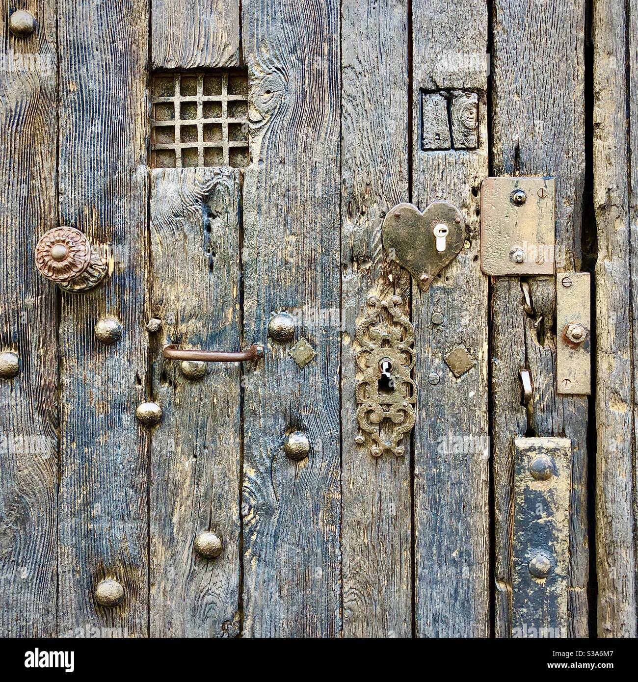 Alte mittelalterliche Eiche verwittert Tür mit eisernen Nieten, Griffe, Eisenwerk und Reparaturen - Tours, Indre-et-Loire, Frankreich. - Smartphone-aufgenommenes Stockfoto