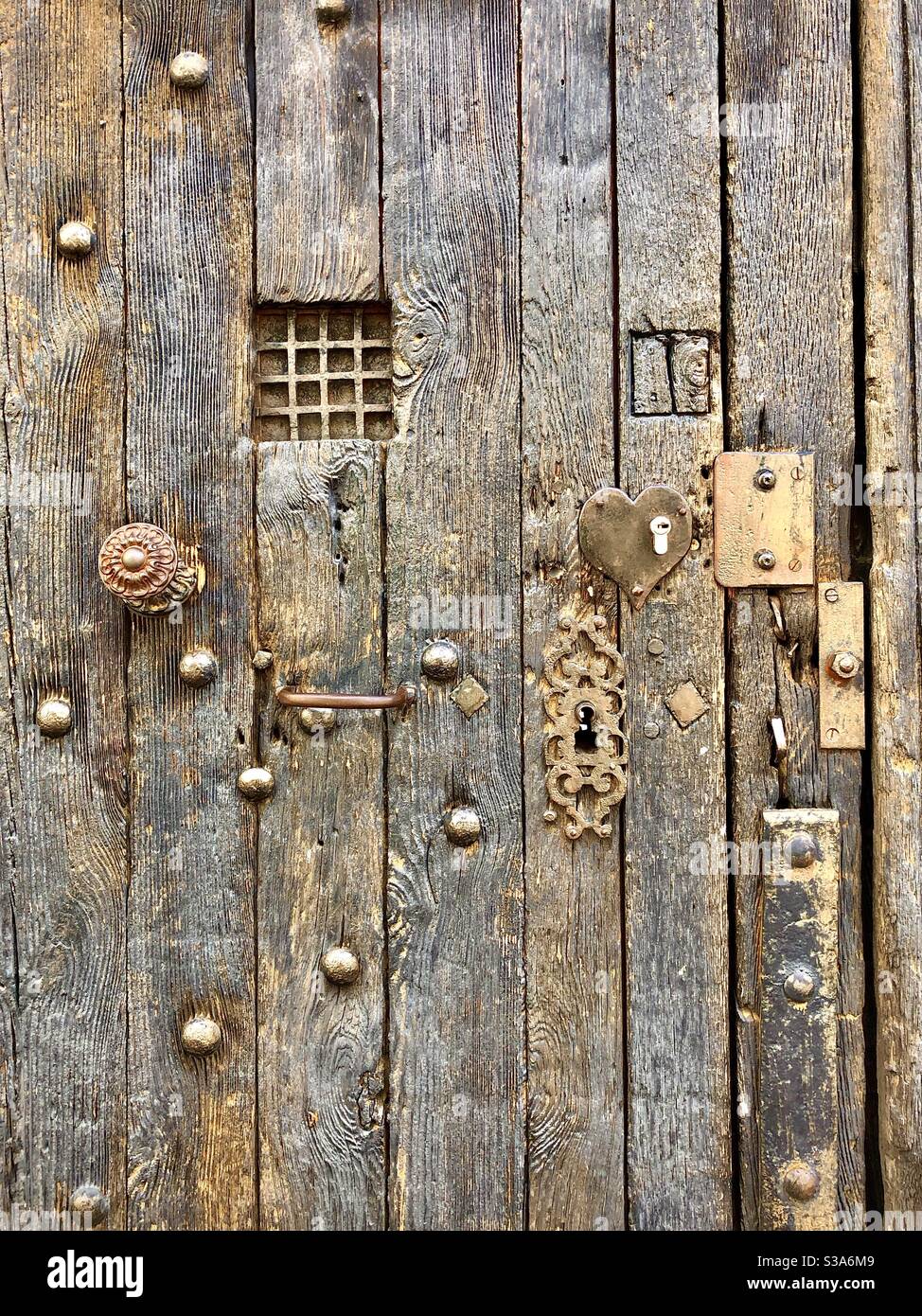Alte mittelalterliche Eiche verwittert Tür mit eisernen Nieten, Griffe, Eisenwerk und Reparaturen - Tours, Indre-et-Loire, Frankreich. Stockfoto
