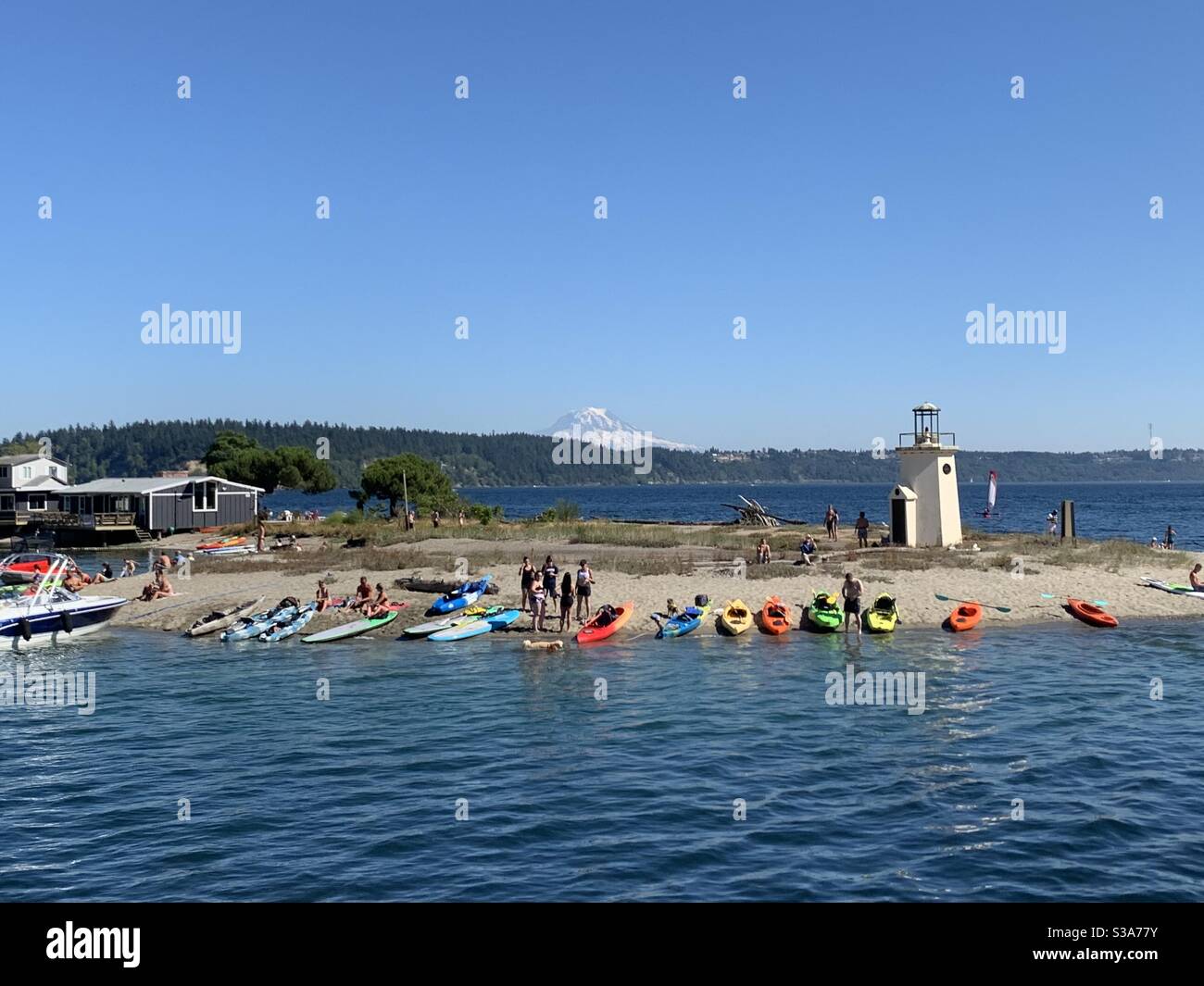 Ein geschäftiger Sommertag mit vielen bunten Kajaks, die den Leuchtturm, Gig Harbor WA, besuchen Stockfoto