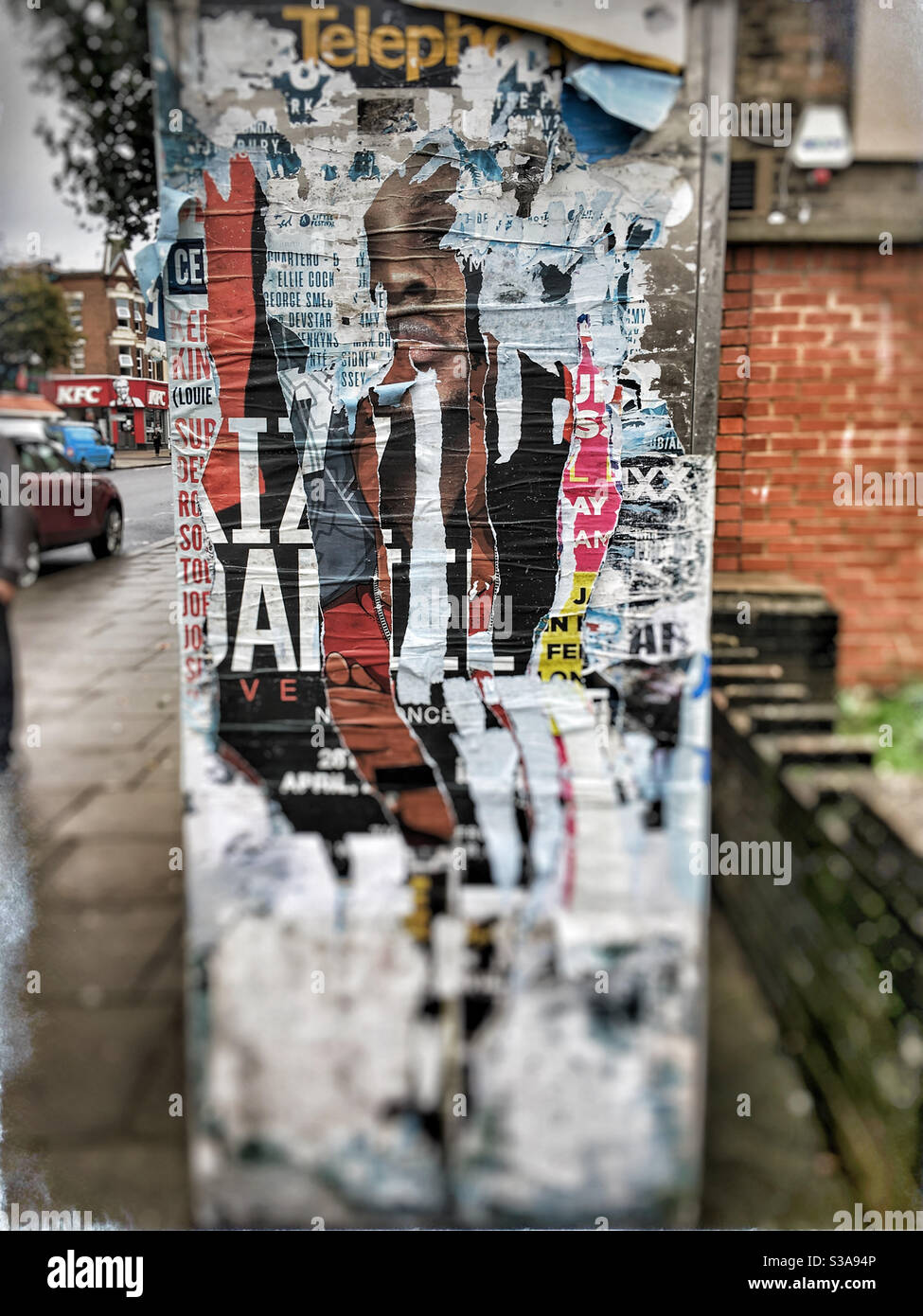 Zerrissene Poster an der Seite einer Telefonbox, East Finchley, London Stockfoto