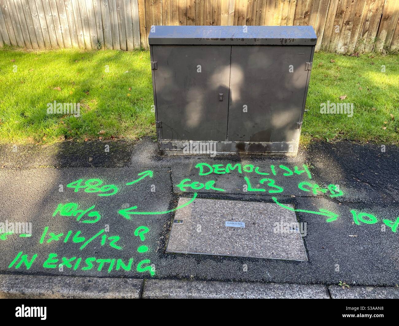 Industrielle Graffiti. Besprühte Markierungen für die Installation neuer Glasfaser-Breitbandkabel. - Smartphone-aufgenommenes Stockfoto