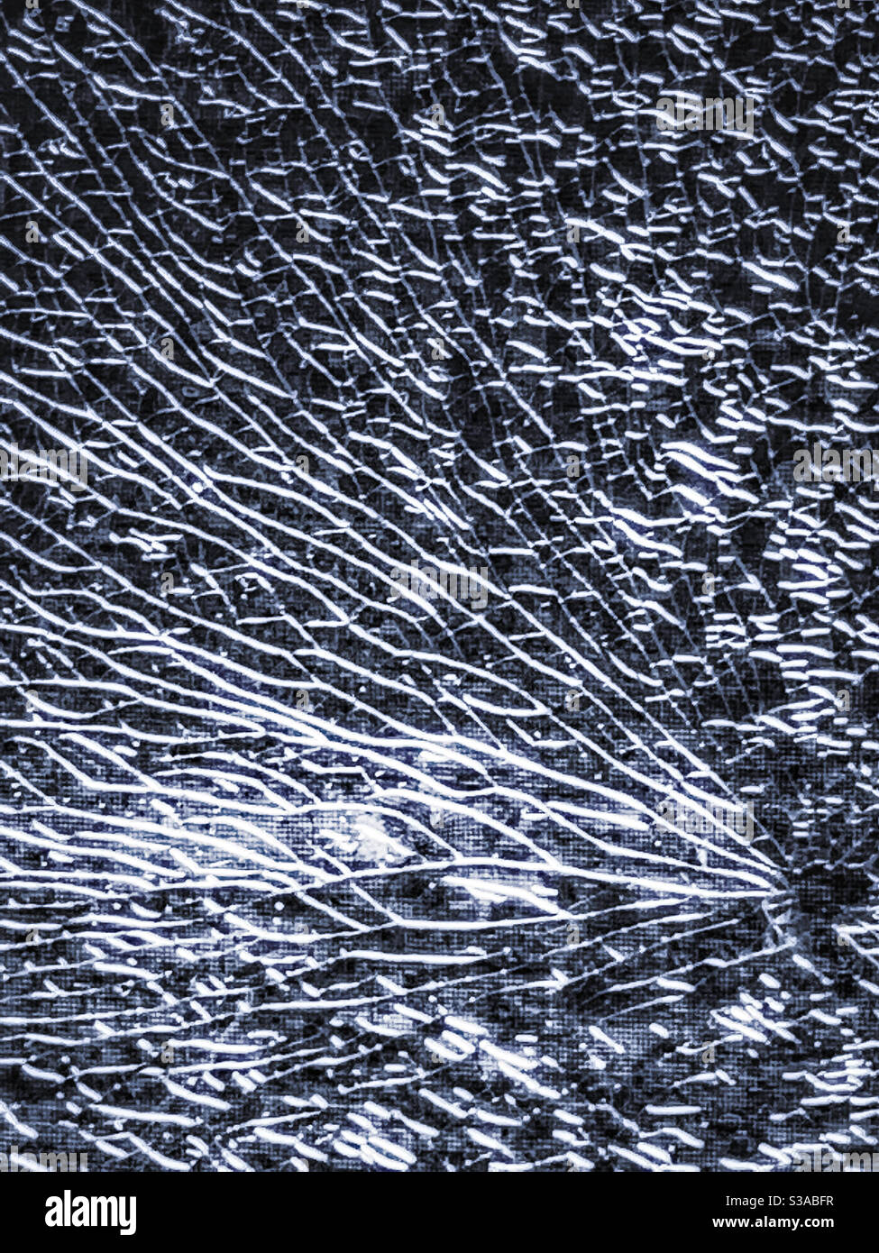Zufällige Kunst. Das schöne Silber auf schwarzen Mustern aus zerbrochenem Glas, eine Tür, die von einem Stein zerbrochen wurde, der von einem Mäher hochgeworfen wurde Stockfoto