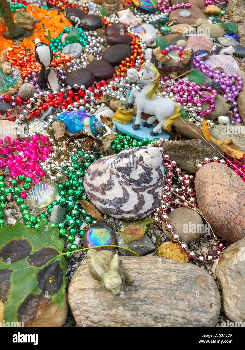 Funkeln und bunte Schmuckstücke schmücken einen Garten. - Smartphone-aufgenommenes Stockfoto