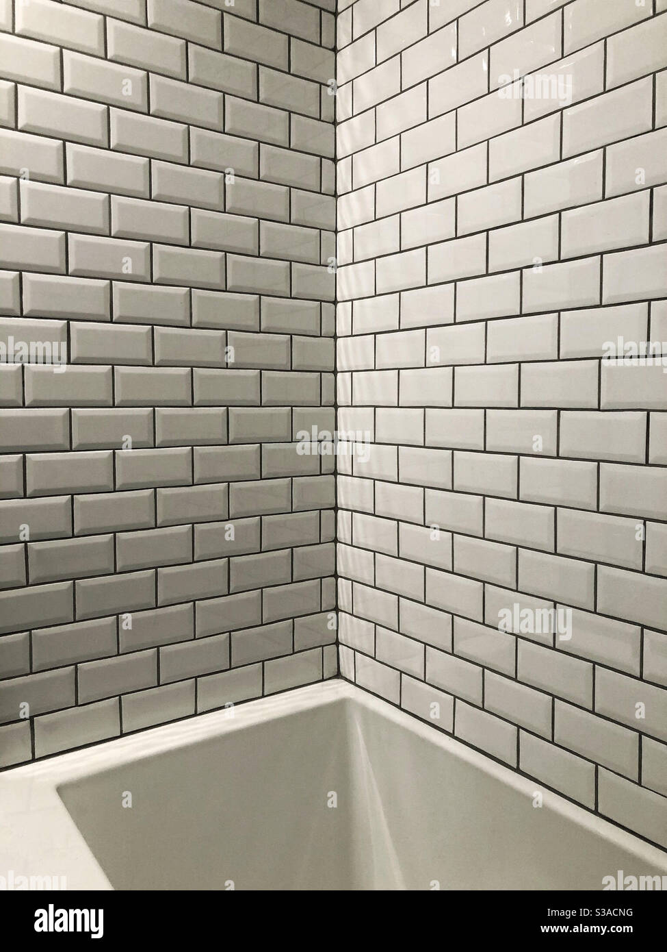 Dusche und Badewanne mit U-Bahnfliesen und dunklen Fugen Stockfoto