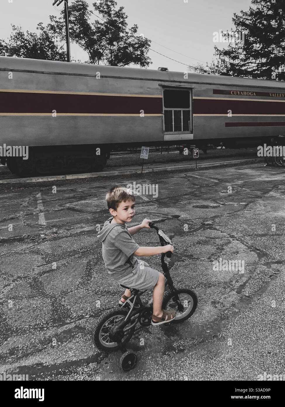 Junge, der sein Fahrrad durch einen verlassenen Zug fährt Stockfoto