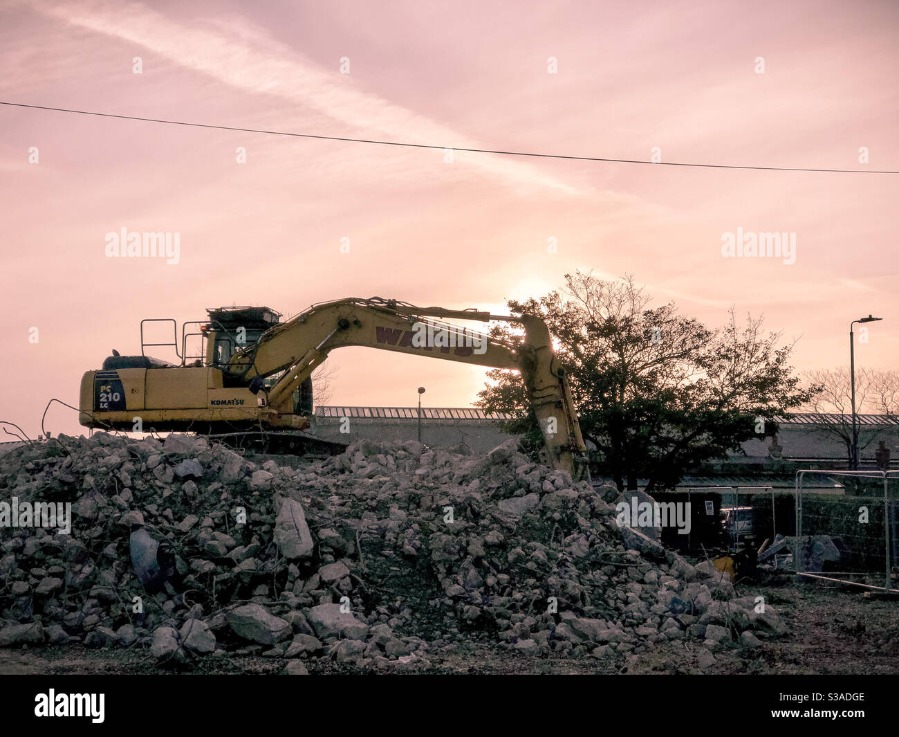 Bagger auf Schutt auf Abbruchstelle am Ende des Tages Stockfoto