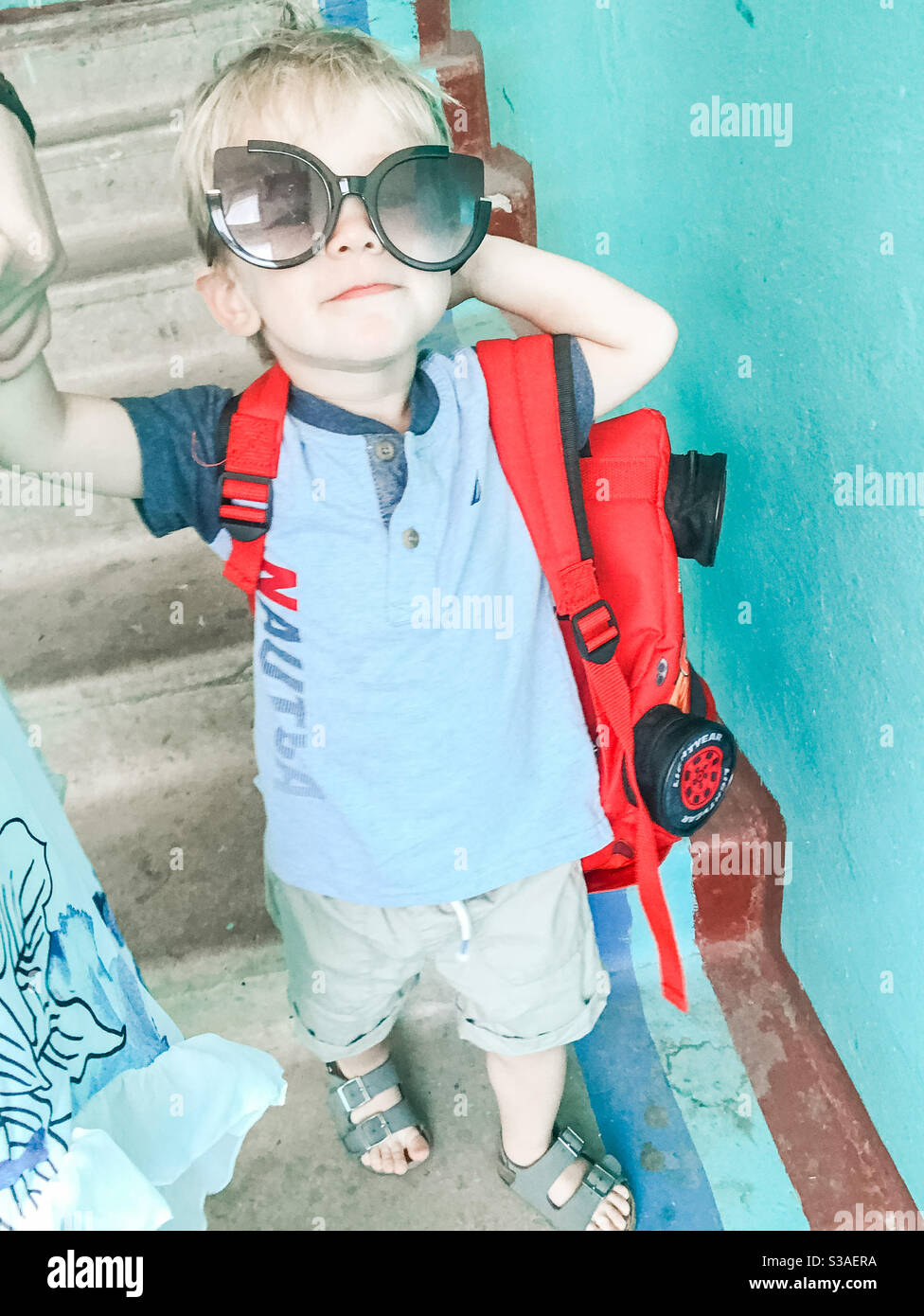 Zwei Jahre alter Junge repariert seine Sonnenbrille und geht nach unten Stockfoto