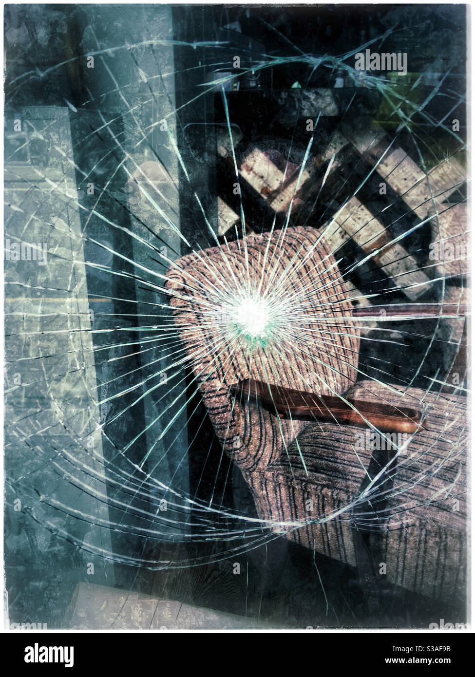 Sessel durch ein zerbrochenes Fenster gesehen Stockfoto