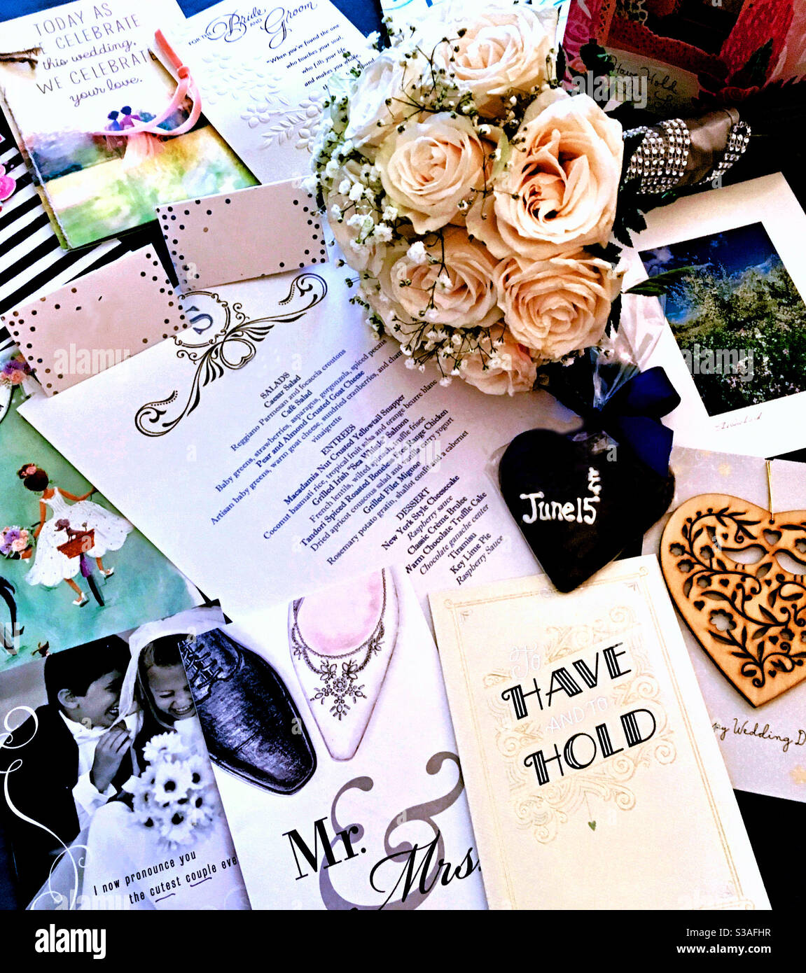 Eine Collage aus Hochzeitskarten, Menü, Pralinen und Brautstrauß aus rosa Rosen. - Smartphone-aufgenommenes Stockfoto